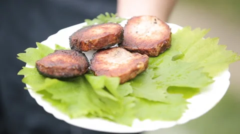 Meat on a plate with grape leaves Stock Footage 64639993