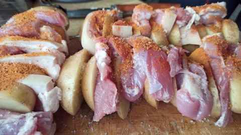 Meat with potatoes on a skewer sprinkle with pepper Vidéo 163225754