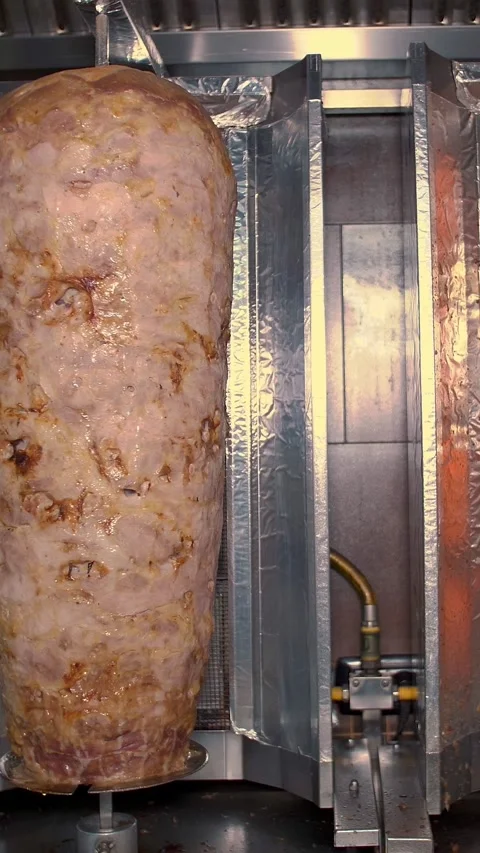 The meat is prepared on a vertical grill for shawarma and pizza. Stock Footage 314889652