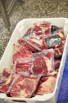 Meat processing plant. Slices of cut beef on the conveyor. Stock Photos