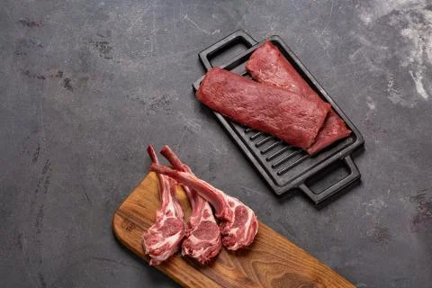 Meat Raw Fresh Mutton on the bone Spices Chesno and Rosemary on a black backg Stock Photos
