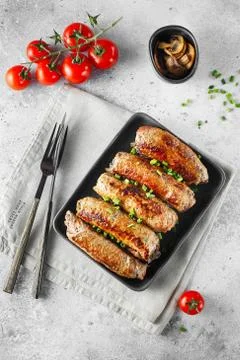 Meat rolls stuffed with Champignon served with tomatoes and green onions in h Stock Photos