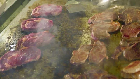 Meat sizzling on a grill during cooking in 4K slow motion 120fps Stock Footage 285882845