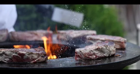 Meat sizzling on an open flame grill during a barbecue cookout. Stock Footage 311673503