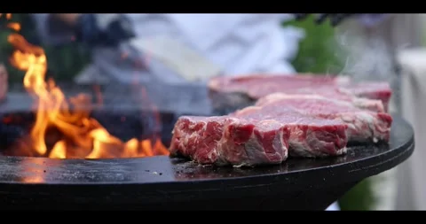 Meat sizzling on an open flame grill during a barbecue cookout. Stock Footage 311673514