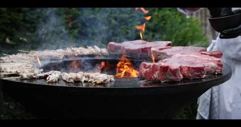 Meat sizzling on an open flame grill during a barbecue cookout. Stock Footage 311673515