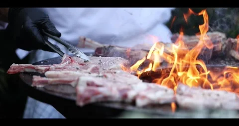 Meat sizzling on an open flame grill during a barbecue cookout. Stock Footage 311673524