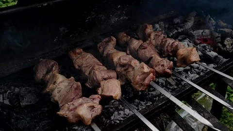 Meat on skewers. Close-up process of cooking yummy shashlik in nature. Stock Footage 154223559
