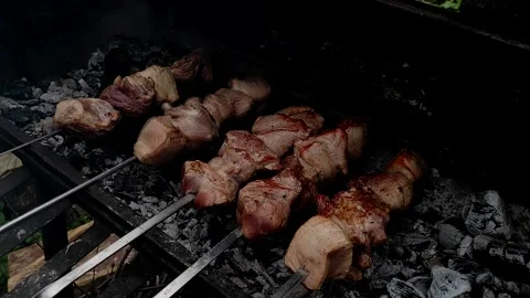 Meat on skewers. Close-up process of cooking yummy shashlik in nature. Stock Footage 154223615