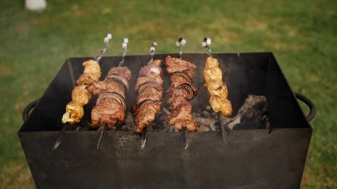 The meat on skewers is fried in a grill. Close-up. Shot with motion. Slow motion Stock Footage 130166902