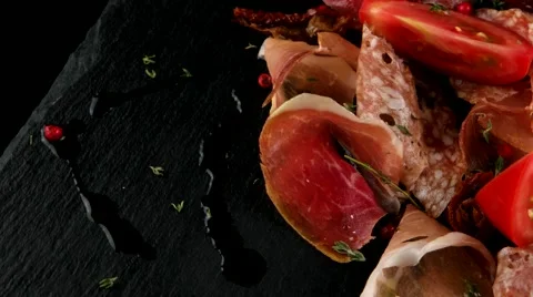 Meat slices, ham, salami, bacon, on the black stone tray, closeup, loop Stock Footage 66482161