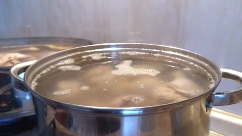Meat soup is slowly boiling in a large metal pot Stock Footage 323222447