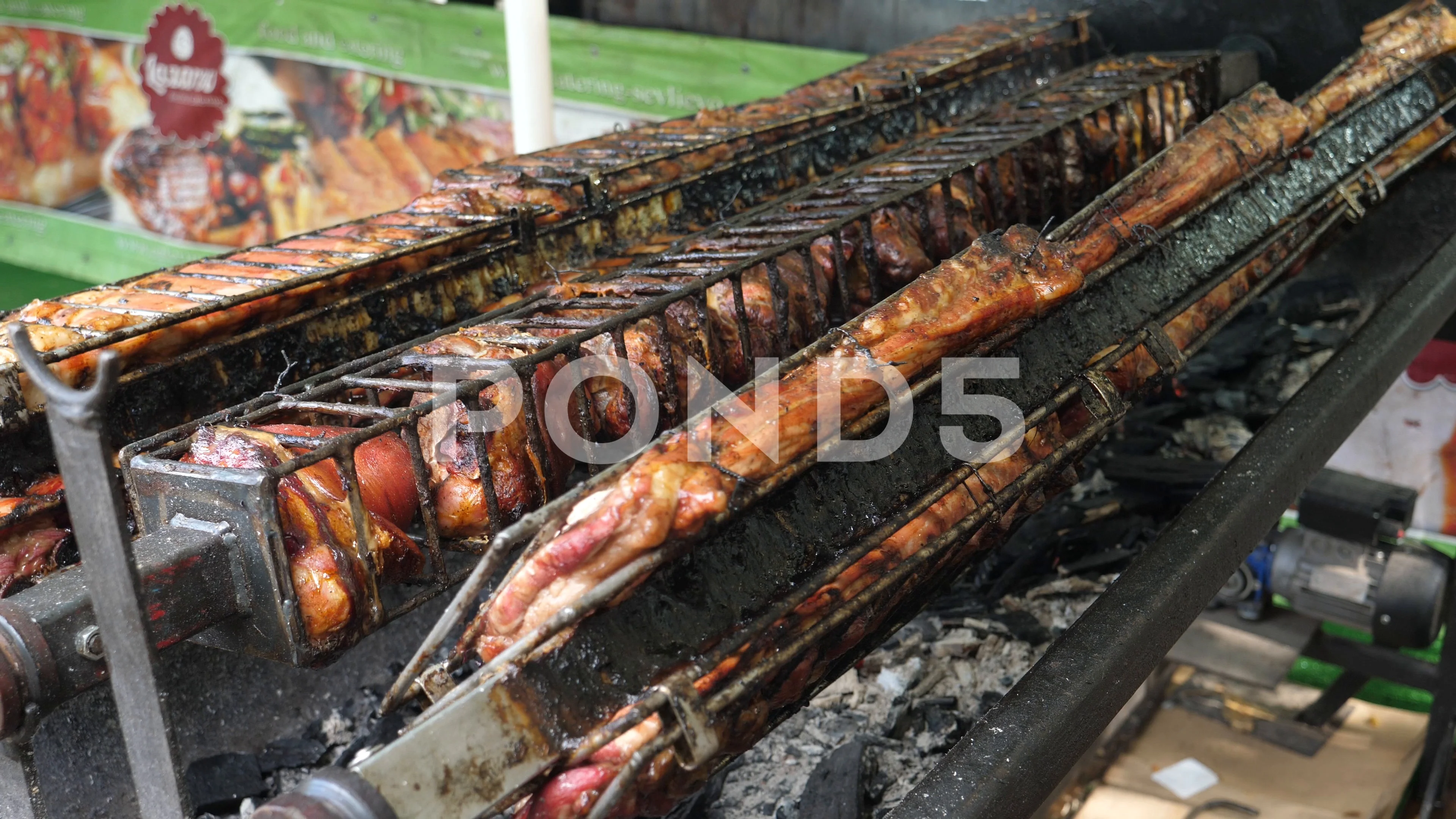 Meat spinning on spit cooking balkan meat dishes at street food festival