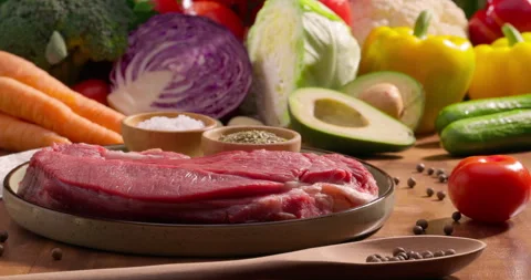 Meat steak with fresh vegetables on the background. Balanced meal preparation Stock Footage 313078086