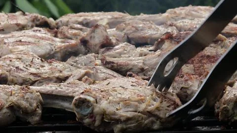 A meat steak fried on a wire rack with smoke and fire 스톡 사진