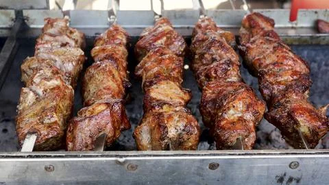A meat steak fried on a wire rack with smoke and fire 스톡 사진