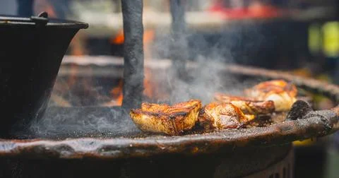 Meat steaks grilling on open fire with smoke and flame. Barbecue cooking on.. Stock-Fotos
