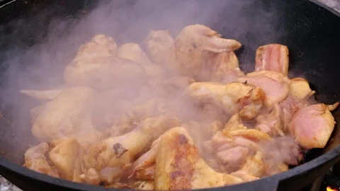The meat is stewed in a cauldron. Chicken meat is stewed in a cauldron. A dish o Stock Footage 283629751