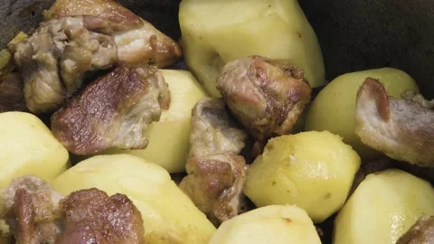 Meat is stewed with potatoes close-up. Fried meat with potatoes in the process Stock Footage 204855876