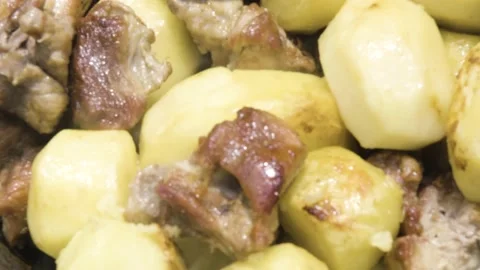 Meat is stewed with potatoes close-up. Fried meat with potatoes in the process Vídeo Stock 208935889