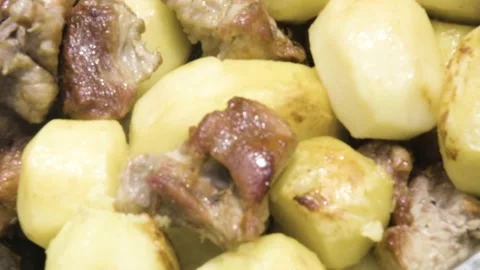 Meat is stewed with potatoes close-up. Fried meat with potatoes in the process Stock Footage 211088636