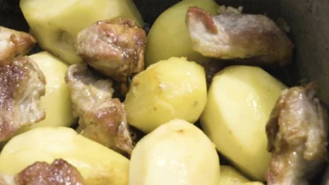 Meat is stewed with potatoes close-up. Fried meat with potatoes in the process Stock-Footage 211088945