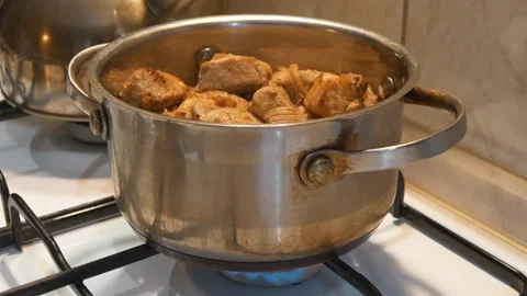 Meat is stewing. There is pot of meat on gas stove. Cooking Stock Footage 321559739