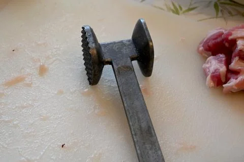 Meat tenderizer on a cutting board 库存照片