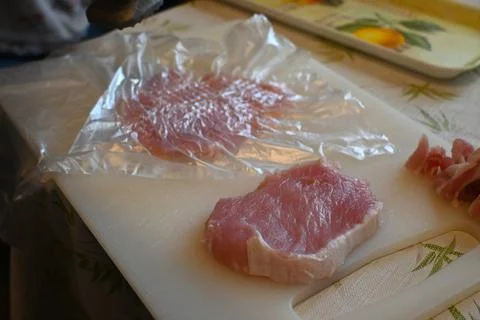 Meat tenderizing on a cutting board Фото