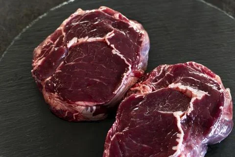 Meat texture, raw steak close up, Ribeye on black background Stock Photos