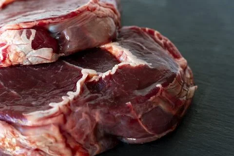 Meat texture, raw steak close up, Ribeye on black background Stock Photos