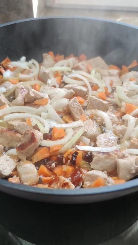 Meat with vegetables is stewed in a frying pan close-up Stock Footage 234201876