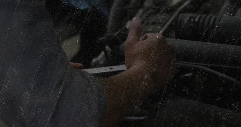 Mechanic adjusting engine hose inside auto garage, with floating airflow graph Video stock 308101414