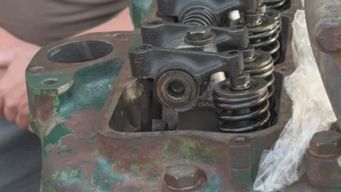 Mechanic adjusting old tractor engine valve lash Stock Footage 339037872