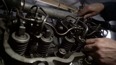 The mechanic adjusts the valve on the diesel engine. In hands tools Video stock 75050415