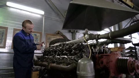 The mechanic adjusts the valve on the diesel engine. In hands tools Video stock 75075733
