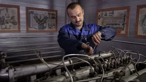 The mechanic adjusts the valve on the diesel engine. In hands tools Video stock 75130801