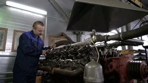 The mechanic adjusts the valve on the diesel engine. In hands tools Stock Footage 75132756