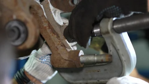 Mechanic aligns a new silent block into knuckle using C-clamp. 스톡 동영상 345908888