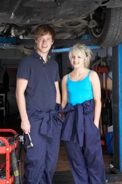 Mechanic and apprentice working on car Stock Photos