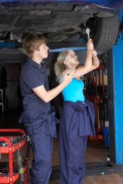 Mechanic and apprentice working on car Stock Photos