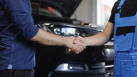 Mechanic and customer shaking hands in an auto repair shop, car service. Two Stock Footage 203716617
