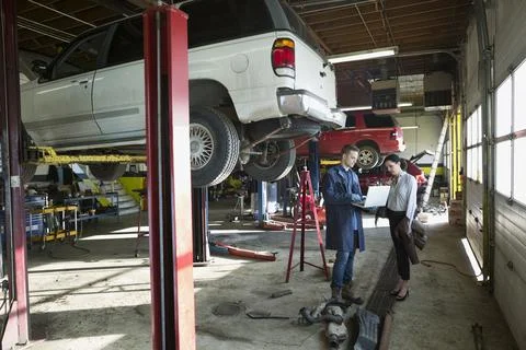 Mechanic and customer using laptop auto repair shop Photos