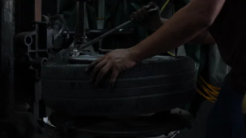 Mechanic applying grease for remove old damaged and worn out of car tire trea Stock Footage 147368373