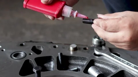 Mechanic Applying Liquid Threadlocker Adhesive To Engine Stud Bolt. Stock Footage 344677050
