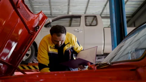 Mechanic Asian man using clipboard file examining tuning repairing car engine Stock Footage 265082890