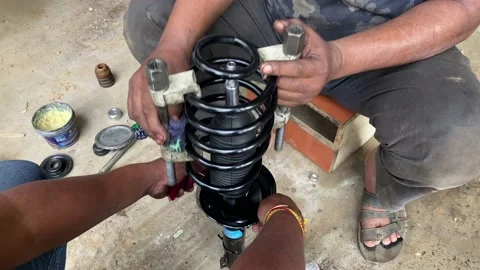 Mechanic assemble socker coils spring in garage Video stock 160988854