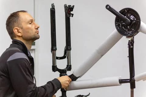 Mechanic assembling a bicycle frame in a workshop Foto stock
