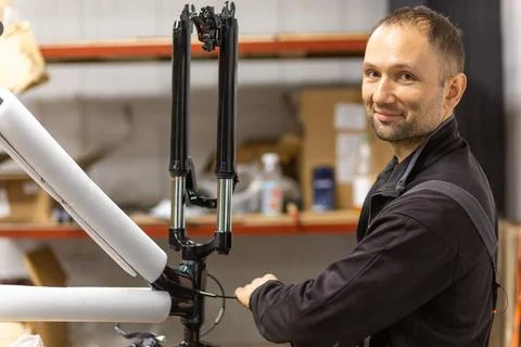 Mechanic assembling a bicycle frame in a workshop Stock Photos
