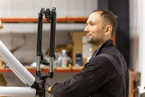 Mechanic assembling a bicycle frame in a workshop Stock Photos